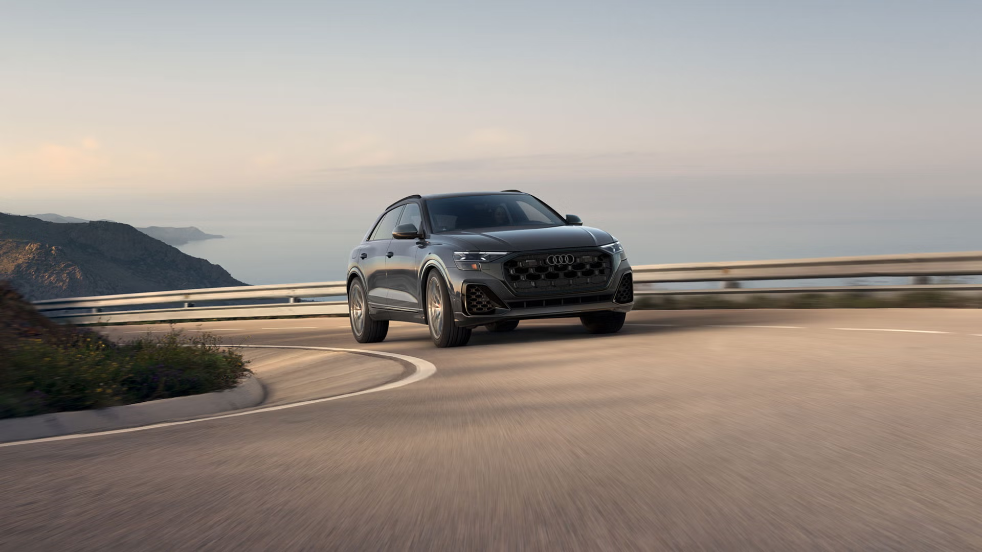 Left side profile view of an Audi SQ8 accelerating.